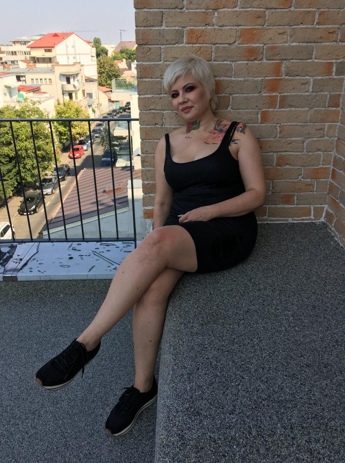 Catinca Roman îmbrăcată cu o rochie neagră mulată, fără mâneci