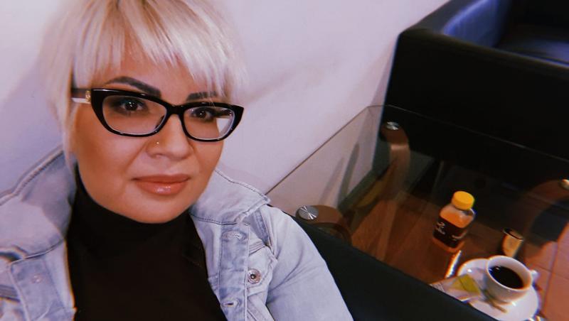 Catinca Roman îmbrăcată cu o bluză neagră sub o jachetă din denim