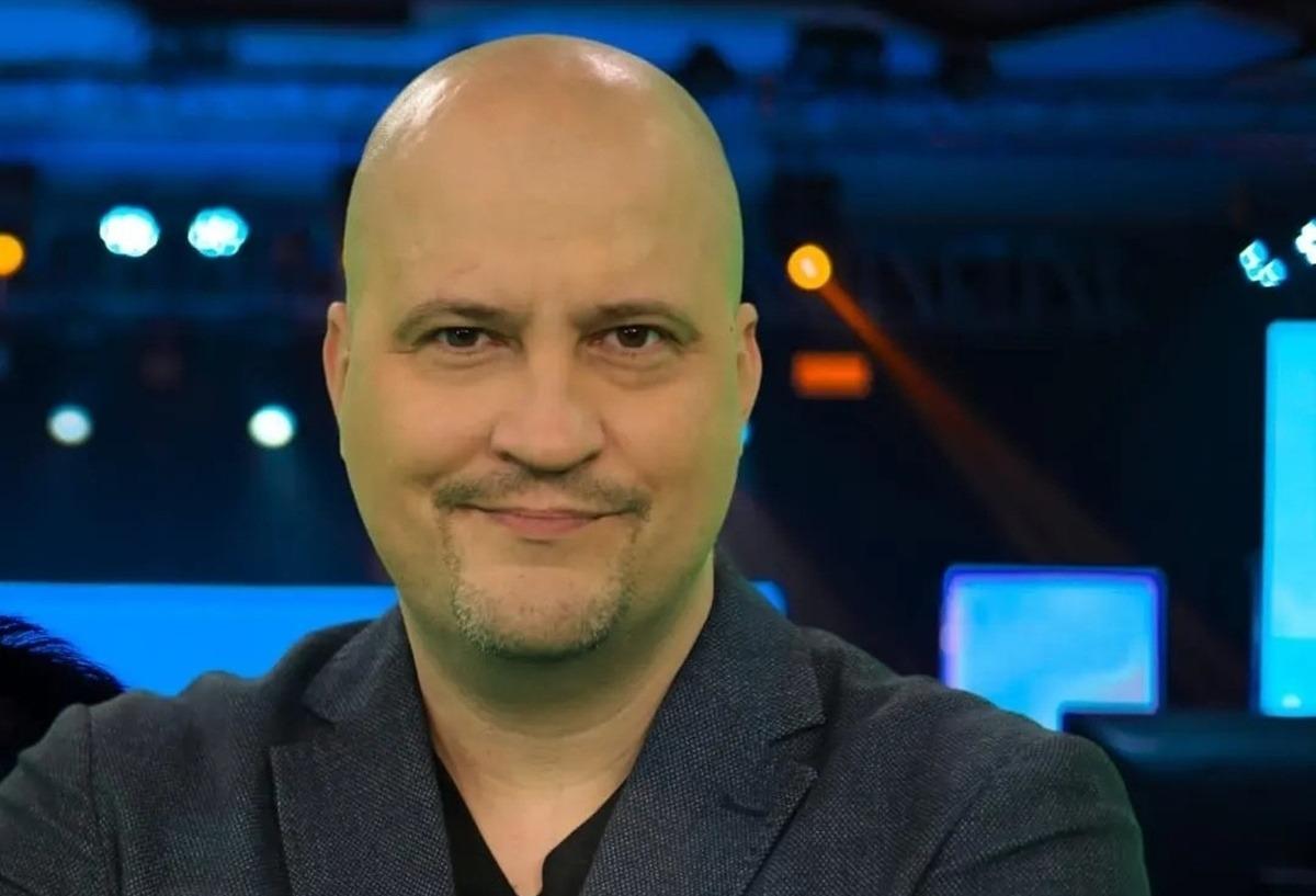 Șerban Huidu îmbrăcat cu un sacou gri, peste un tricou neagru