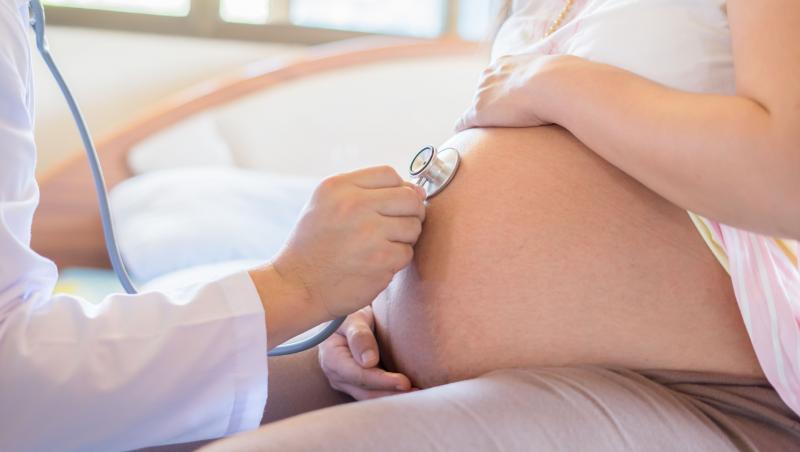 Doctor folosind stetoscop alb examinând o femeie însărcinată în clinică, examen medical concept nou-născut