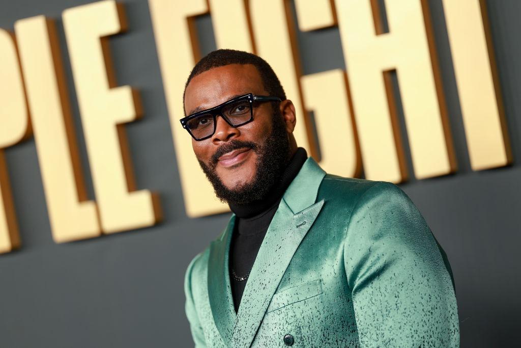 Tyler Perry îmbrăcat cu un sacou verde peste o bluză neagră