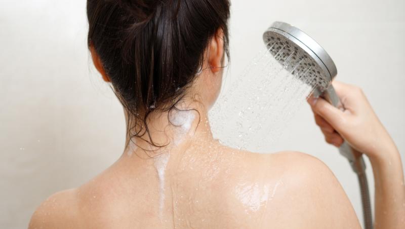 o femeie cu spatele care face duș