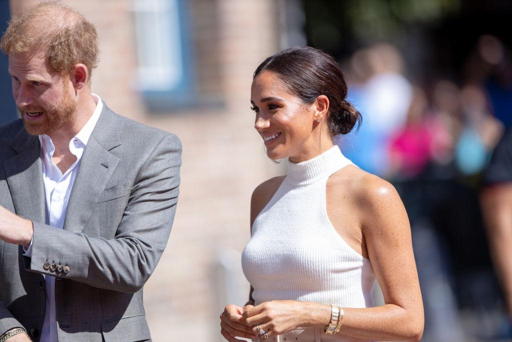 Meghan Markle alături de soțul ei, ambii îmbrăcați în ținute elegante