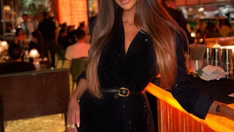 Bianca Dragușanu îmbrăcată într-o ținută neagră strălucitoare, la un restaurant