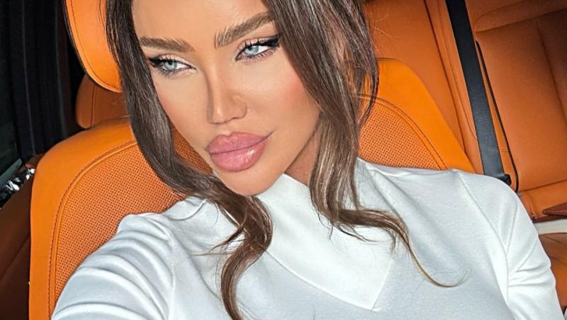 Bianca Dragușanu îmbrăcată cu o bluză albă, pozându-se într-un Rolls Royce