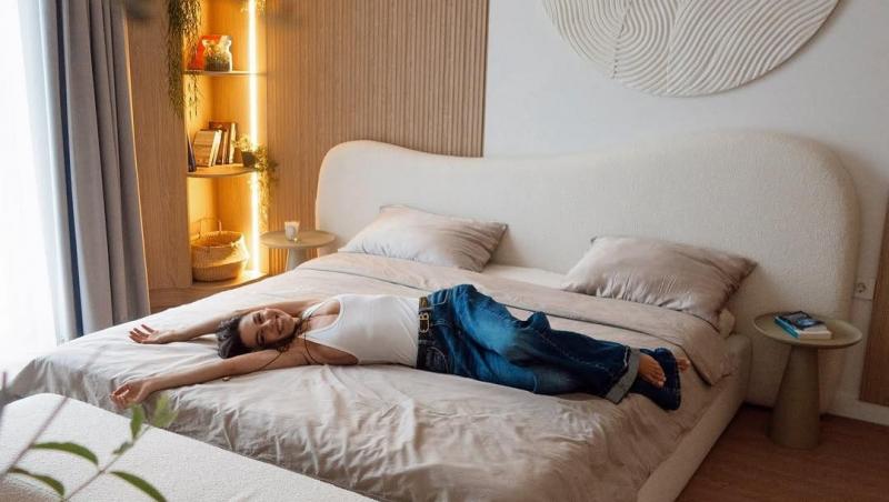 Mira întinsă pe un pat din noua ei casă