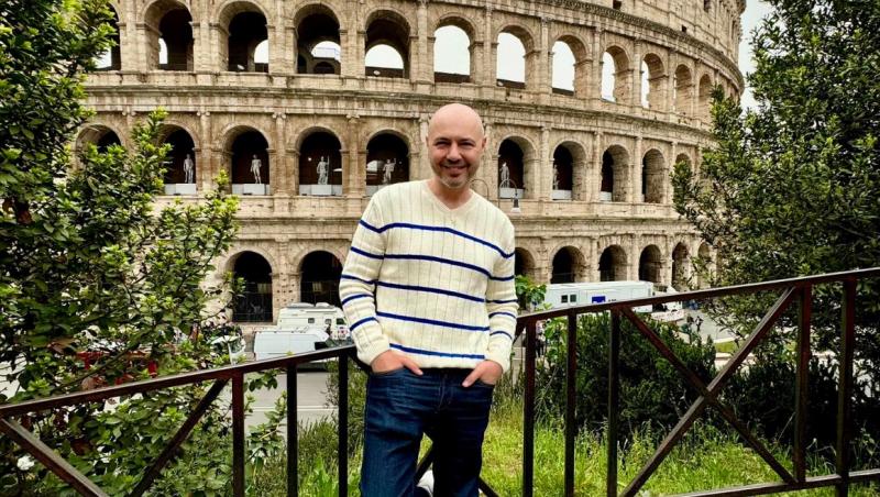 Mihai Mitoșeru îmbrăcat casual, pozând în fața Colosseumului