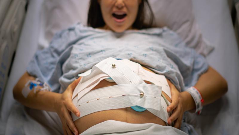 femeie în travaliu pe patul de spital