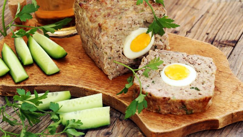 Drob de miel pe un tocător alături de castraveți tăiați