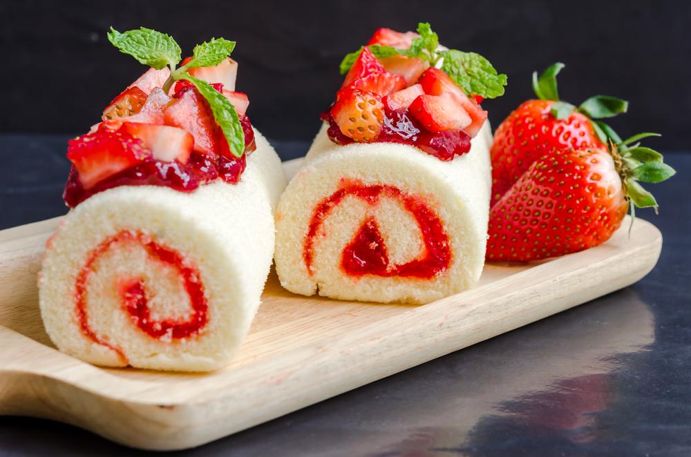 două bucăți de ruladă cu gem pe un platou alb