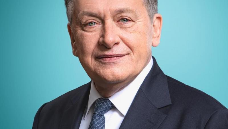 Crin Antonescu îmbrăcat cu un sacou bleumarin, peste o cămașă albă, cu o cravată asortată