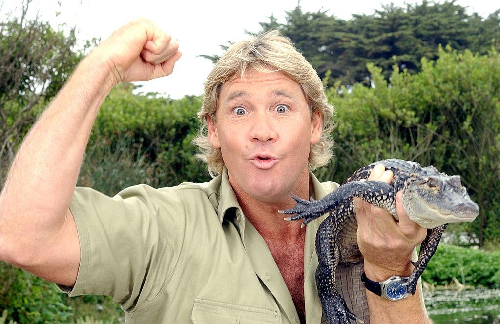 Steve Irwin ținând un pui de crocodil în mână