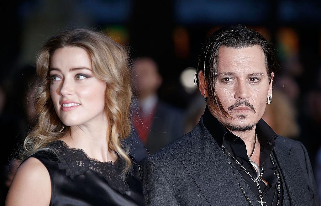 Amber Heard îmbrăcată într-o rochie neagră, alături de Johnny Depp, îmbrăcat cu un costum negru