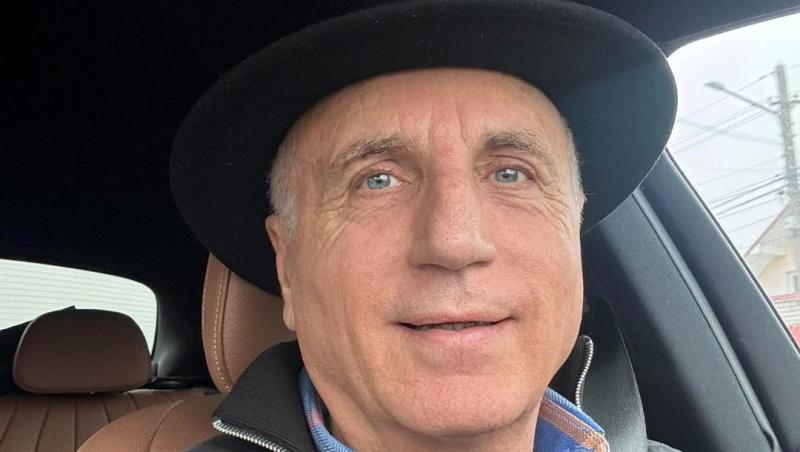 Constantin Enceanu îmbrăcat cu o geacă gri, stând într-o mașină
