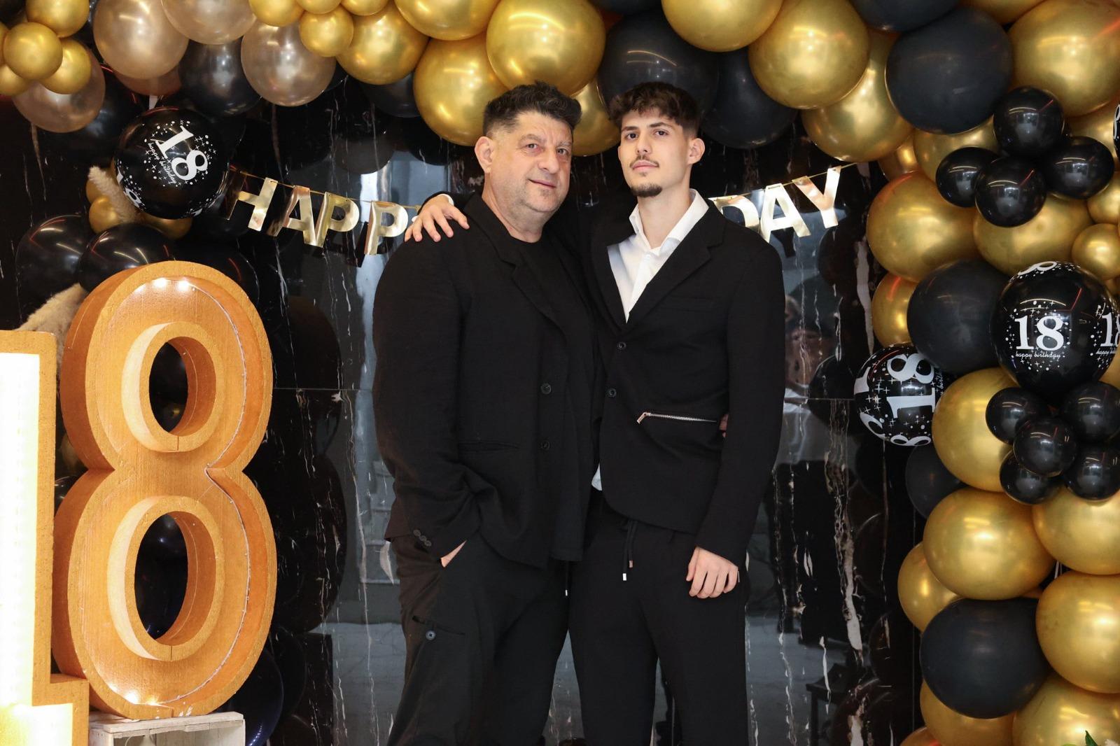 Tavi Colen alături de fiul său la majoratul acestuia, ambii îmbrăcați în negru