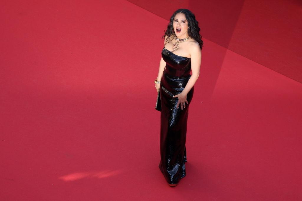 Salma Hayek îmbrăcată într-o rochie neagră mulată, pe covorul roșu