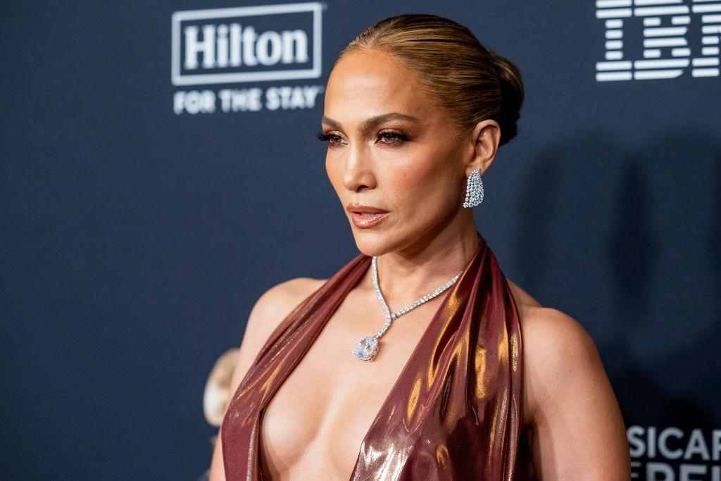 Jennifer Lopez îmbrăcată cu o rochie strălucitoare, extrem de decoltată, accesorizată cu un colier imens