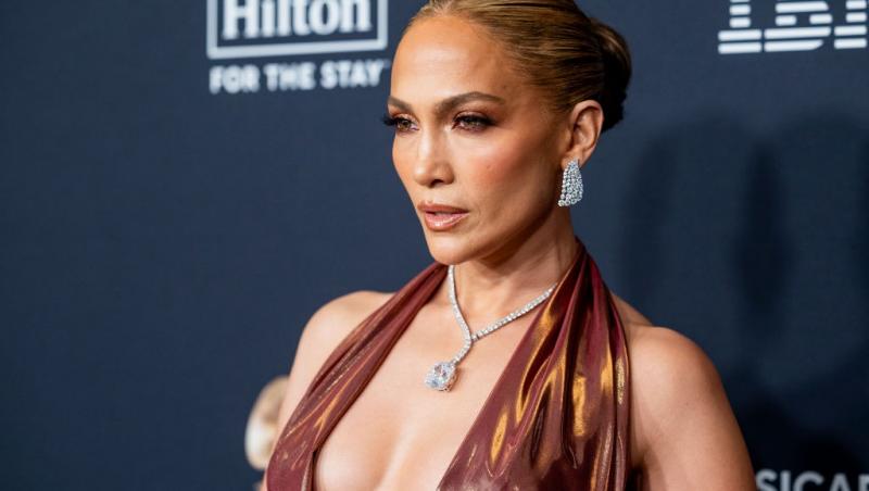 Jennifer Lopez îmbrăcată cu o rochie strălucitoare, extrem de decoltată, accesorizată cu un colier imens
