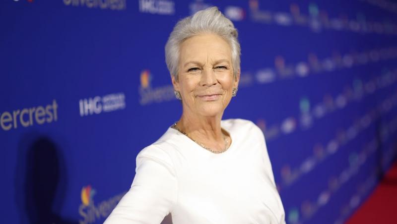 Jamie Lee îmbrăcată cu o rochie albă mulată, cu mâneci lungi