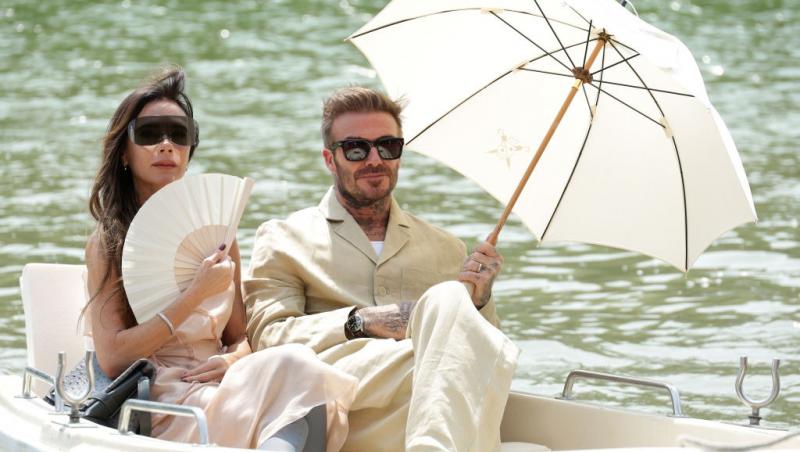 David Beckham alături de soția lui, Victoria, ambii îmbrăcați în bej