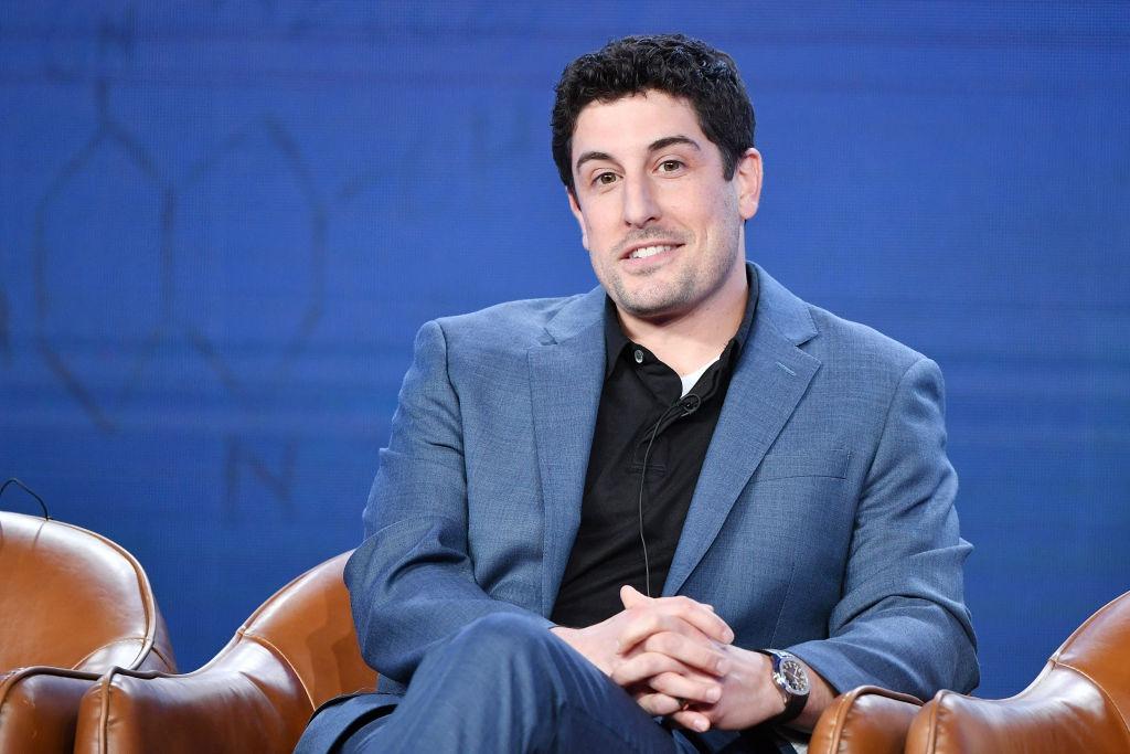 Jason Biggs îmbrăcat cu un costum bleumarin peste o cămașă neagră