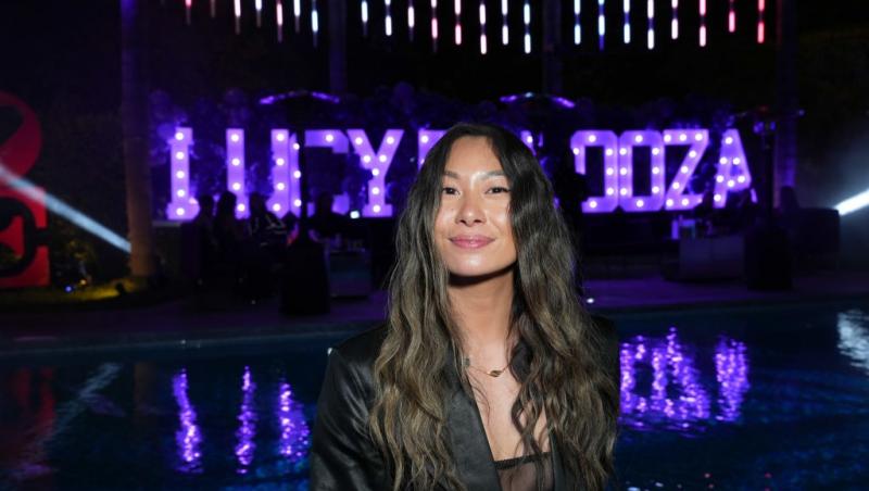 Lucy Guo îmbrăcată cu un top negru, sub un sacou asortat