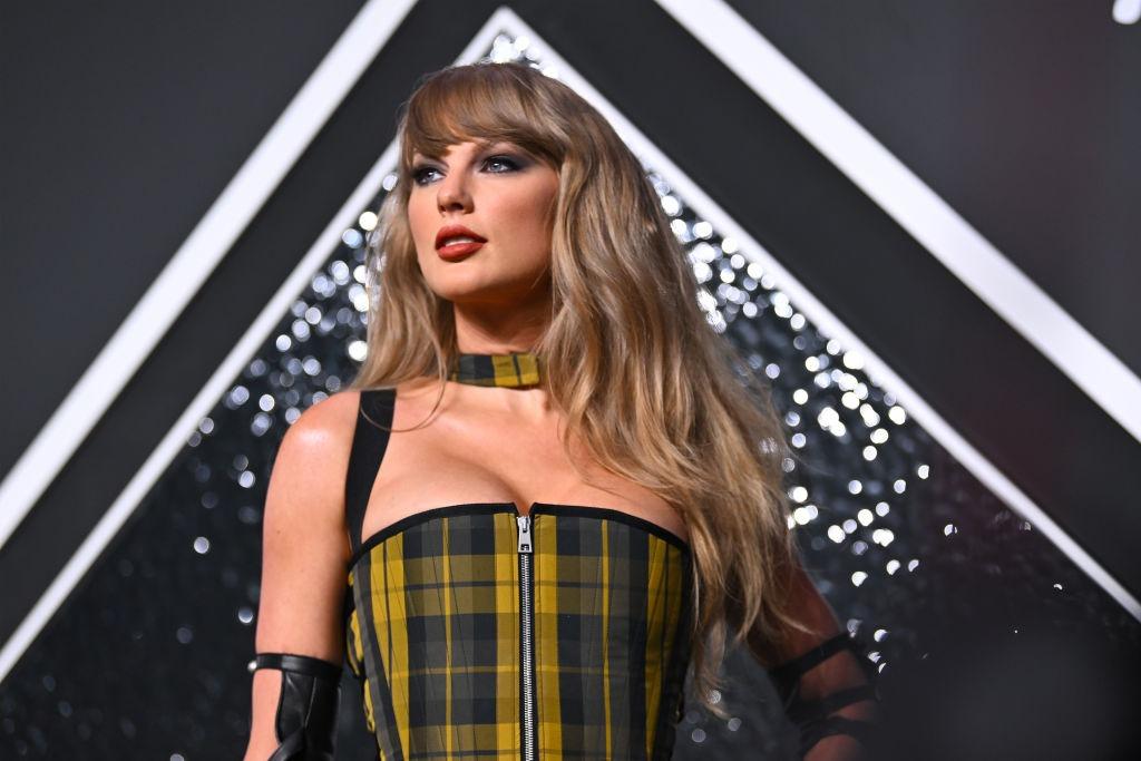 Taylor Swift îmbrăcată într-o rochie în carouri, mulată, fără mâneci