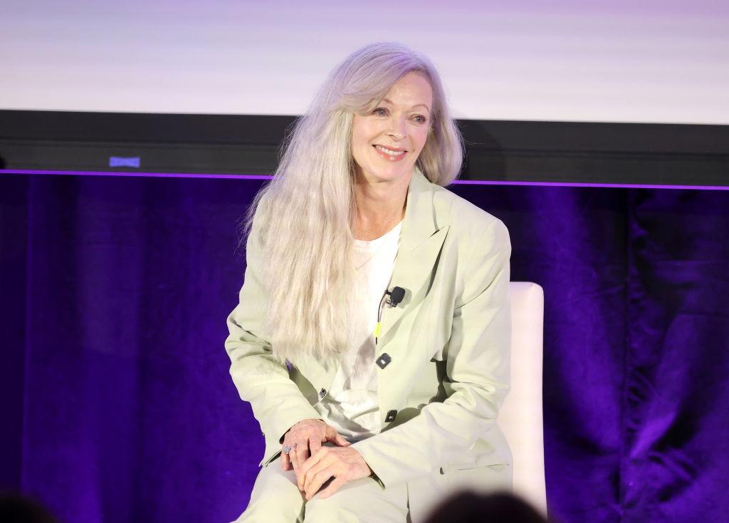 Frances Fisher îmbrăcată cu un costum bej, peste un tricou alb