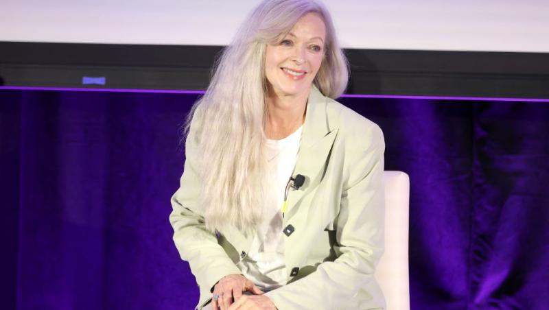 Frances Fisher îmbrăcată cu un costum bej, peste un tricou alb