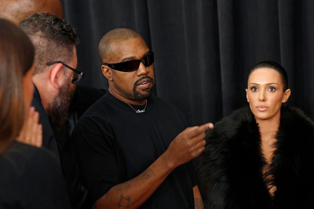 Kanye West îmbrăcat în negru, alături de Bianca Censori