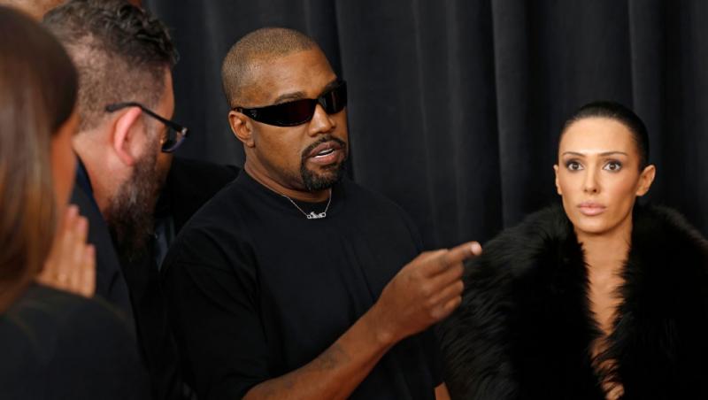 Kanye West îmbrăcat în negru, alături de Bianca Censori
