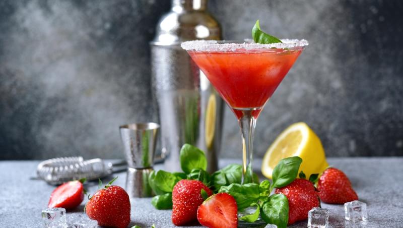 Martini cu căpșuni, shaker și căpșuni proaspete în jur