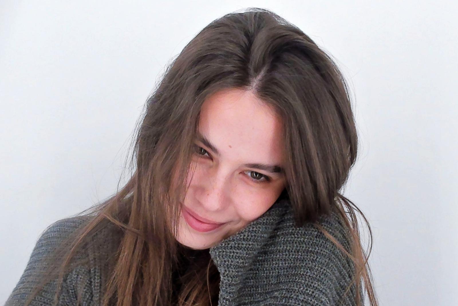 Rebecca Dumitrescu îmbrăcată cu un pulover gri