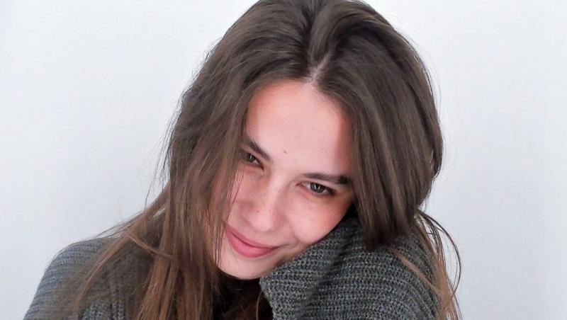 Rebecca Dumitrescu îmbrăcată cu un pulover gri