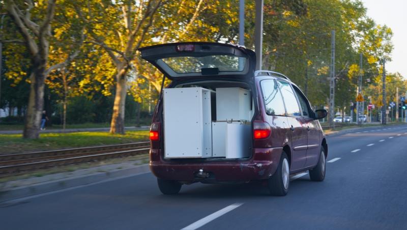 mașină în mers cu portbagajul deschis plin cu mobilă
