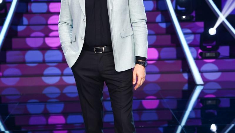 Aurelian Temișan îmbrăcat cu un sacou gri, peste o cămașă neagră