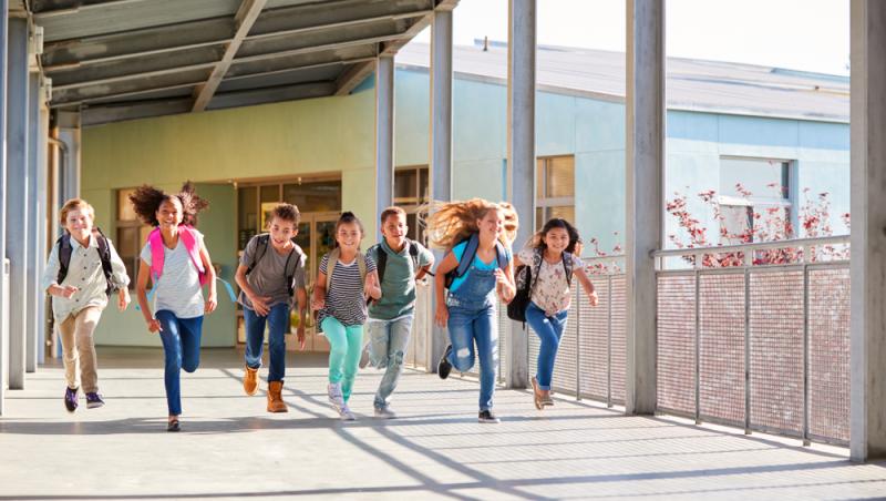 imagine cu un grup de copii alergand in timp ce pleaca de la scoala