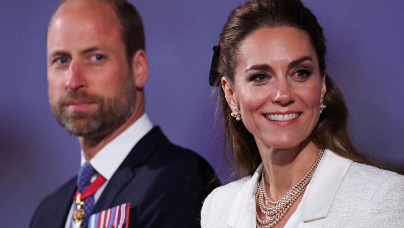 Prințul William îmbrăcat într-un costum negru, alături de Prințesa Kate, îmbrăcată într-un costum alb