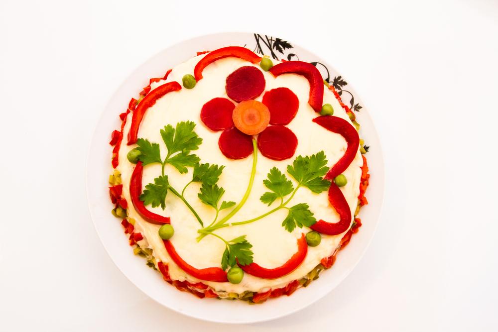 salata de boeuf decorată cu o floare din sfeclă, morcov și frunze de pătrunjel