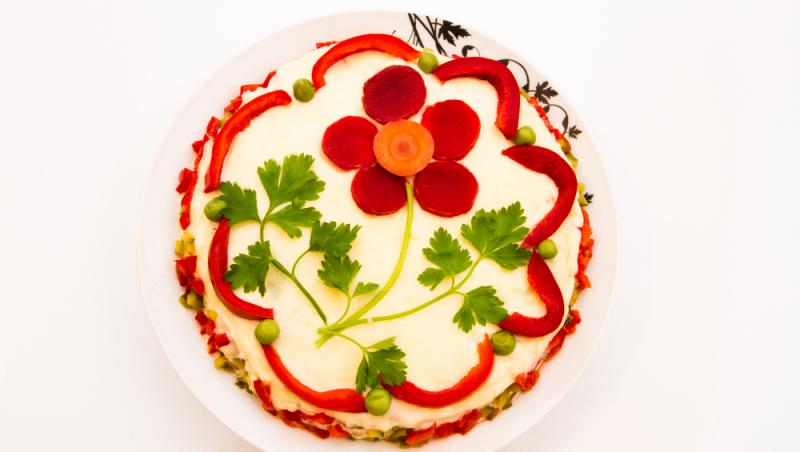salata de boeuf decorată cu o floare din sfeclă, morcov și frunze de pătrunjel