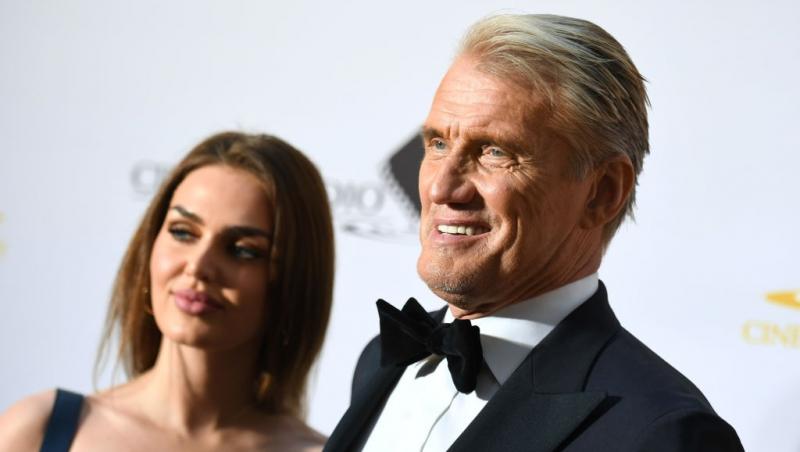 Dolph Lundgren îmbrăcat într-un costum negru, alături de soția lui, îmbrăcată într-o rochie neagră