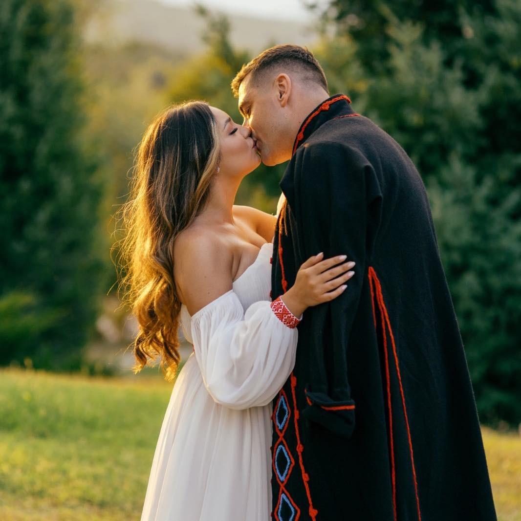 George Simion îmbrăcat în negru, sarutându-și soția, îmbrăcată în alb