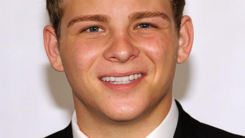 Jonathan Lipnicki îmbrăcat cu un costum negru, peste o cămașă albă