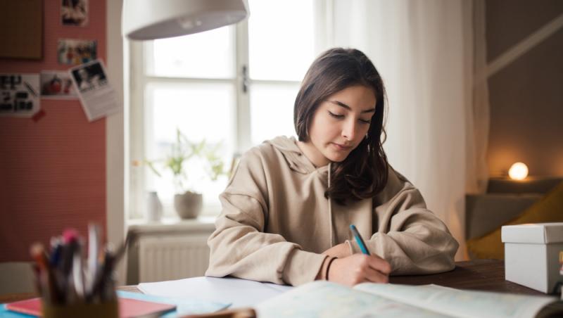 tânără care studiază la birou