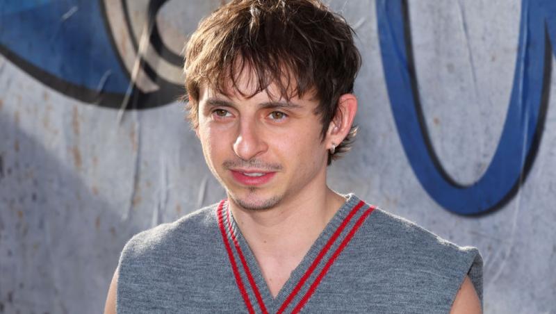 Rico din „Hannah Montana” îmbrăcat cu un maiou gri cu detalii roșii