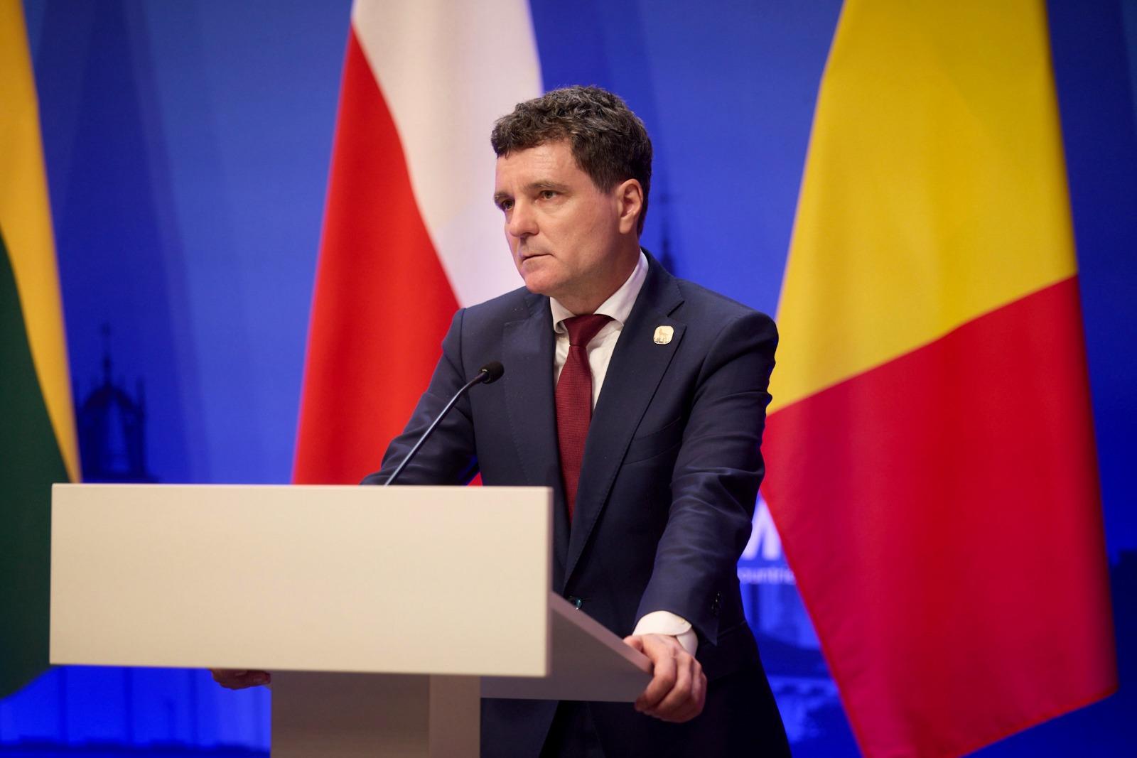 Nicușor Dan îmbrăcat cu un costum bleumarin, vorbind la microfon