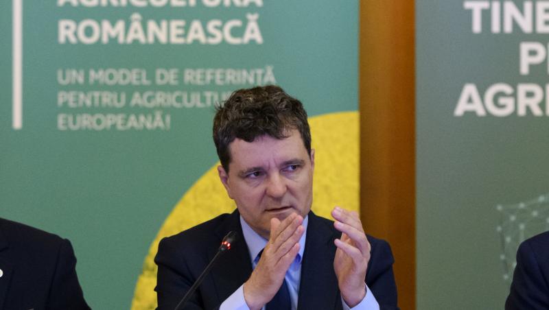 Nicușor Dan îmbrăcat cu un costum negru, vorbind la microfon