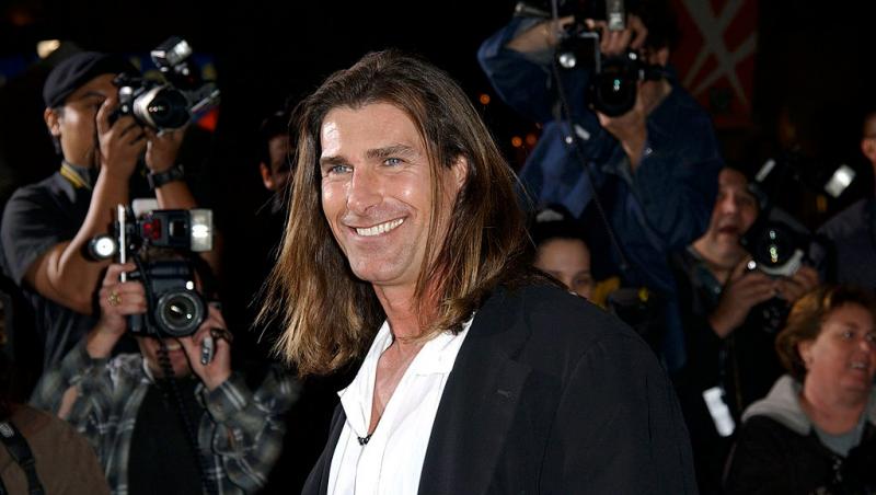 Fabio Lanzoni îmbrăcat cu un sacou negru peste o cămașă albă, zâmbind