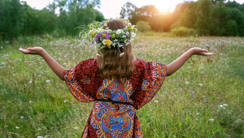 imagine cu o fata pe un camp de flori care priveste catre soare