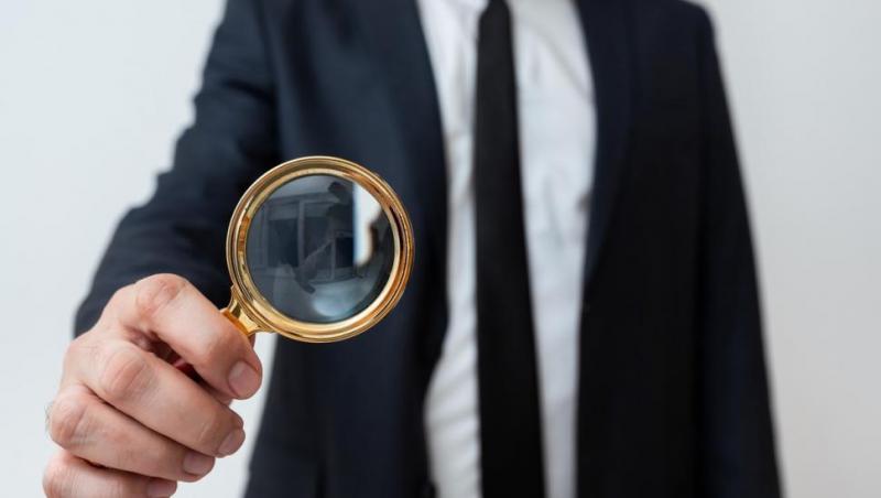 imagine cu un barbat care privește printr-o lupa